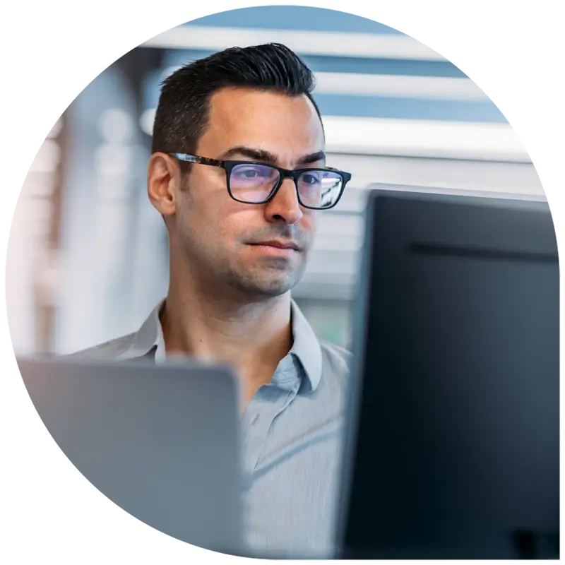 Business professional reviewing Gartner report on laptop in a modern technology office, analyzing public cloud IT trends.