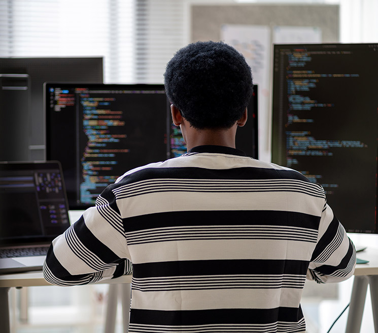 Male working on computer with AI code