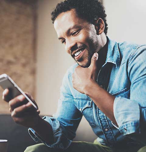 Smiling man using a mobile phone