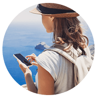 Female tourist on mobile device in front of ocean