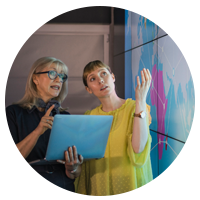 Two business professionals collaborating on projector screen in meeting room