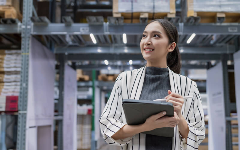 Business owner on tablet checking inventory in warehouse