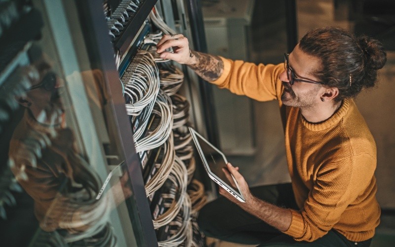 engineer with laptop working on server