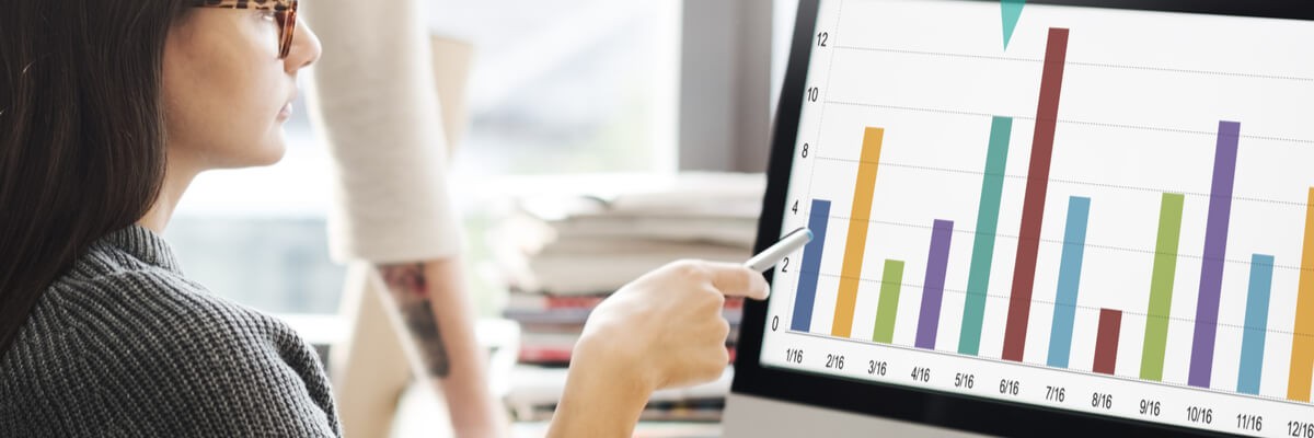 Woman looking at cloud computing statistics on desktop monitor