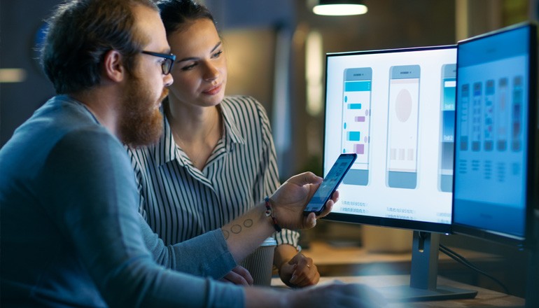 Strengthen your customer relationships Two designers work on mobile app development on computer