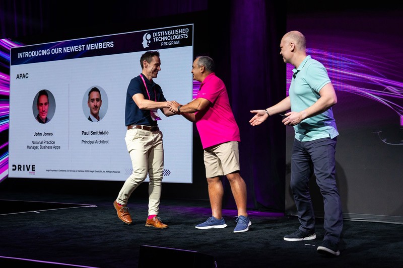 John Jones shakes hand with Juan Orlandini and Phil Hawkshaw at Insight Mastery event 2024