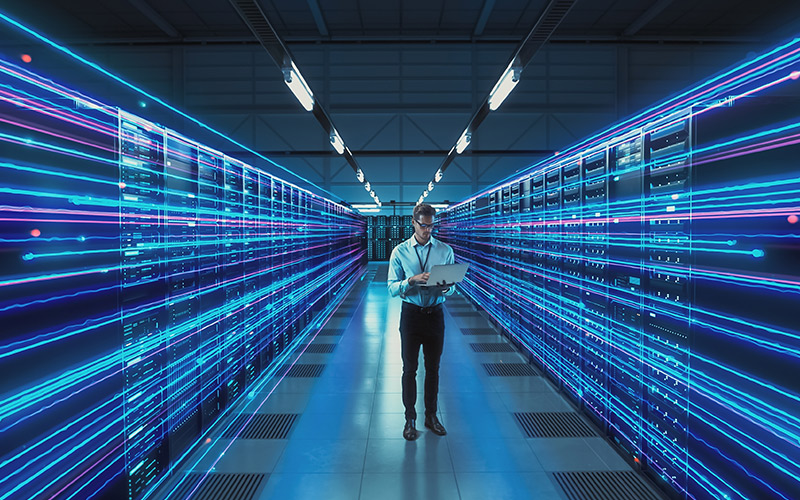 Man in data center on laptop.