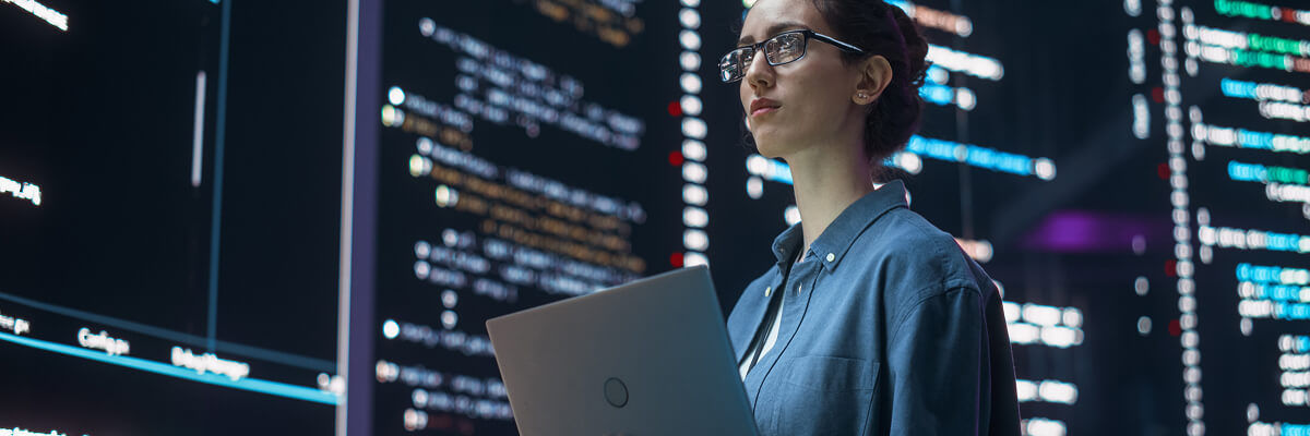 Girl in data center on laptop.