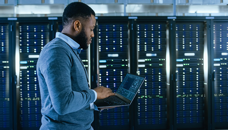 Man on laptop in a data center