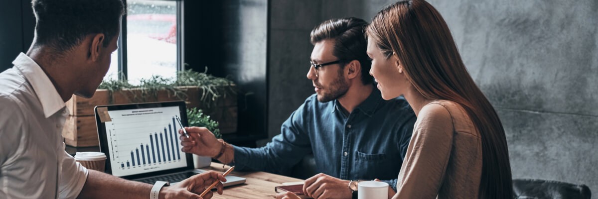 Teammates collaborating around laptop