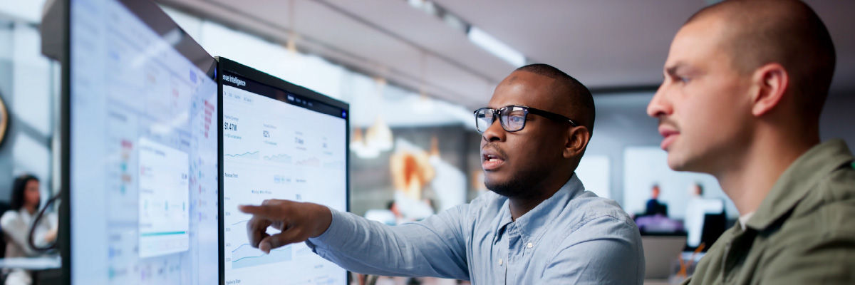 People coding at work on desktops.