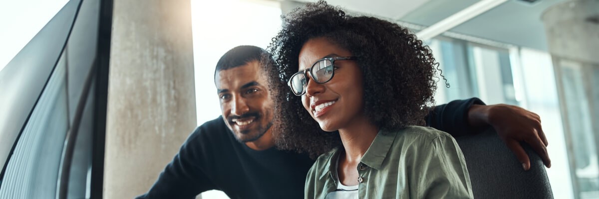 From Outdated to Transformative: Application Modernization Users working together at monitor