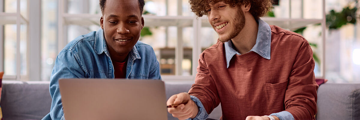 Microsoft 365 E3 and E5 Shift Endpoint Strategy People looking at laptop at work.