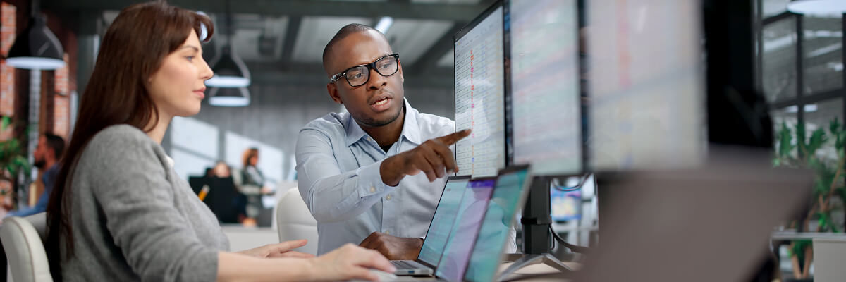 People coding at work on desktops.