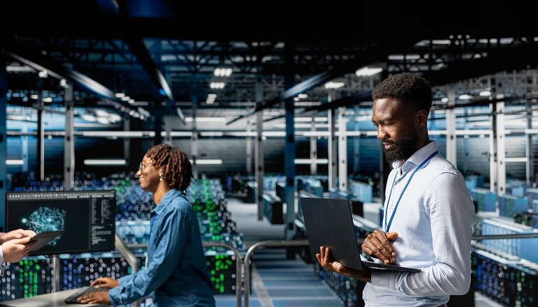 Man in data center on laptop 