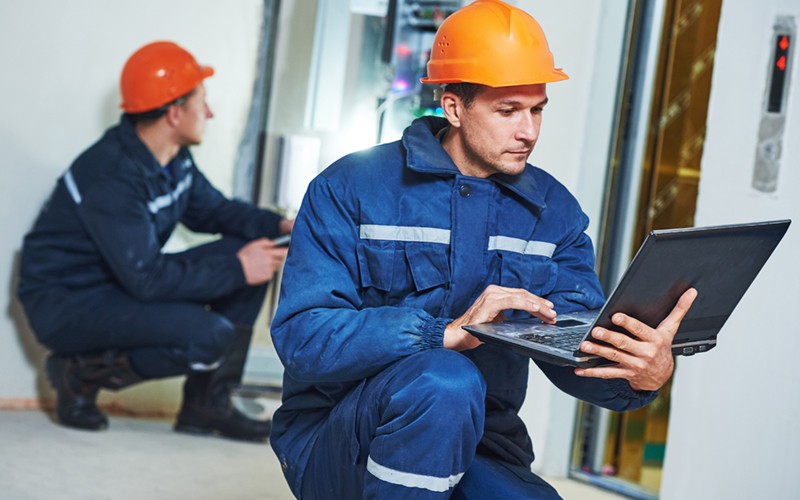 Workers in server room on laptop device