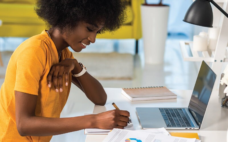 Business professional taking notes in front of secure laptop computer. Cybercriminals. HP Wolf Security