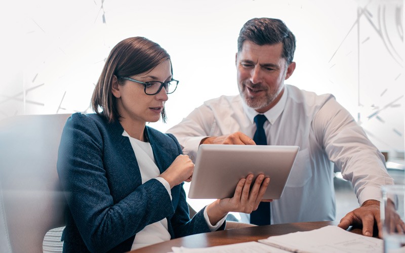 Business professional reading whitepaper off of tablet computer