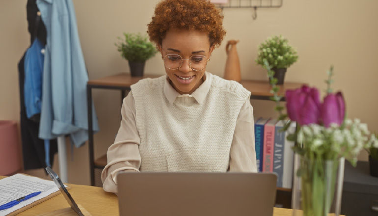 Flowers on desk of a girl working on laptop.