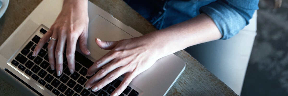 Establish a scalable and manageable Apple environment. close up of hands typing on laptop keyboard. Apple, Jamf, Mac as a Choice, modernization, device management, end-user support, Mac integration