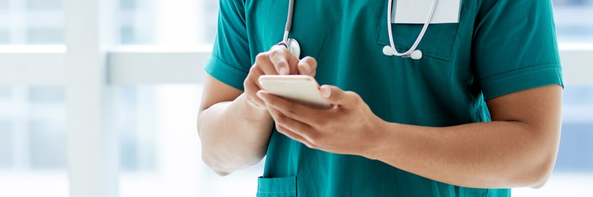 Simplify IT management while improving connectivity and collaboration. Nurse using mobile device to check on patient and send info to doctor