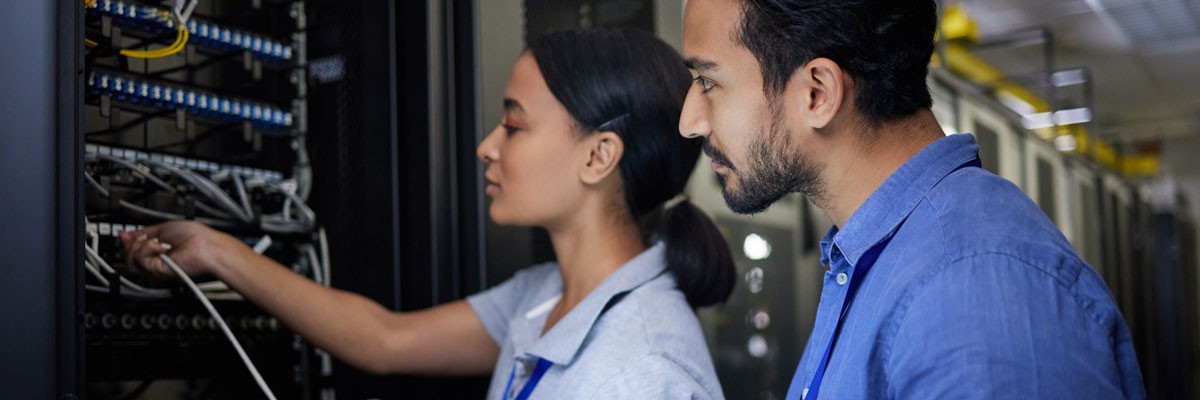 Two IT professionals working in network and server room