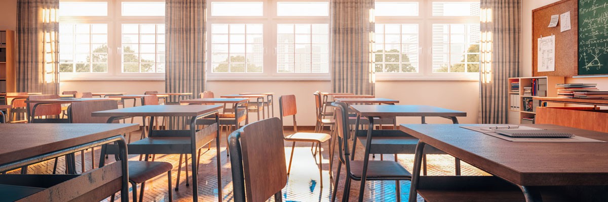 View of empty elementary classroom with light pouring into the windows