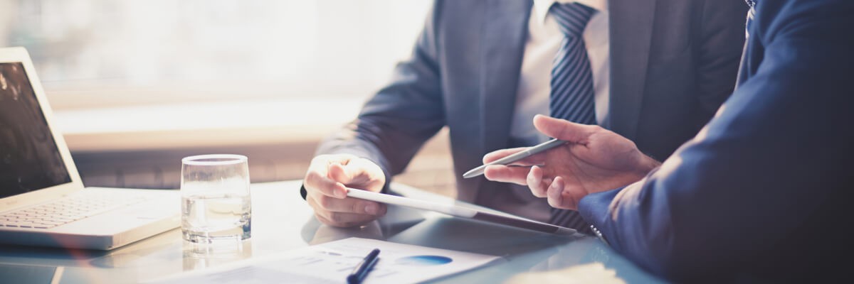 Two corporate coworkers using a tablet