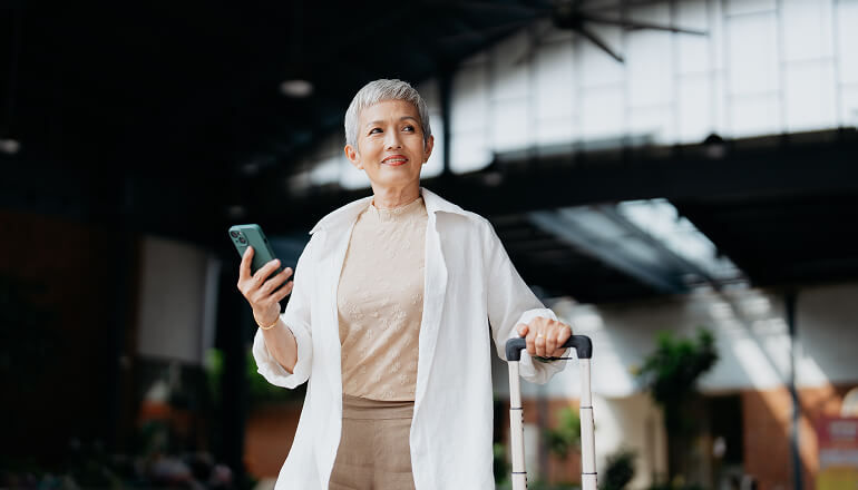 Girl holding phone with a suitcase