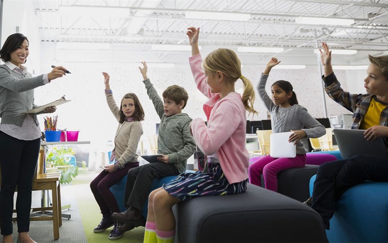 Children raising their hands in a classroom