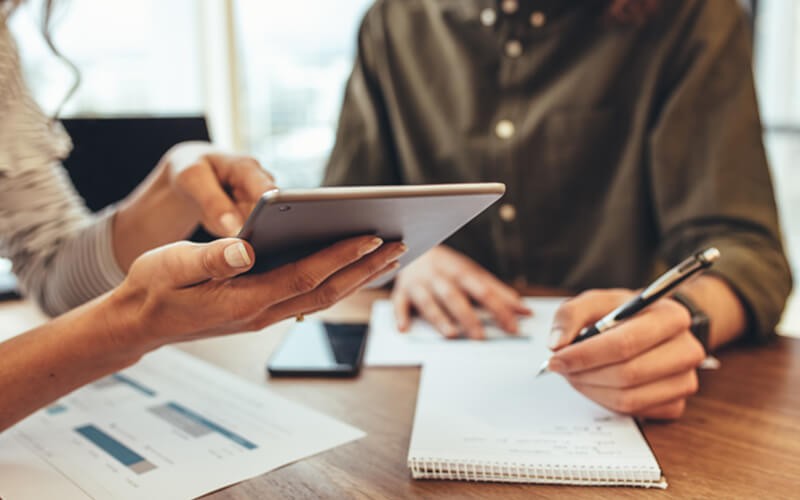 Two business people reading results on tablet device