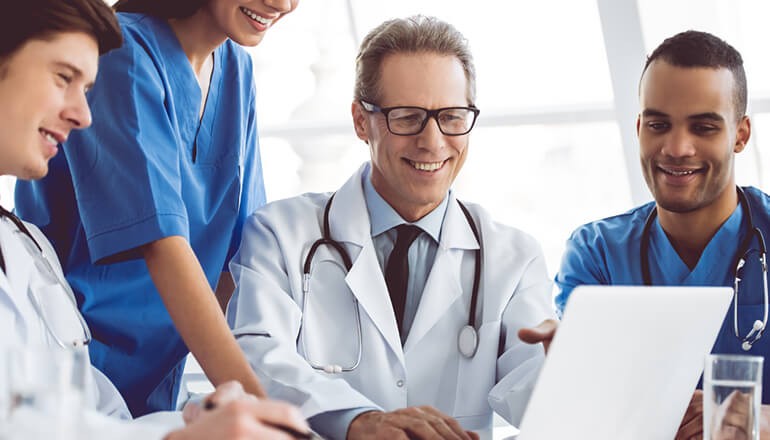 Digital Transformation for Healthcare Group of medical professionals gathered around to watch healthcare webinar