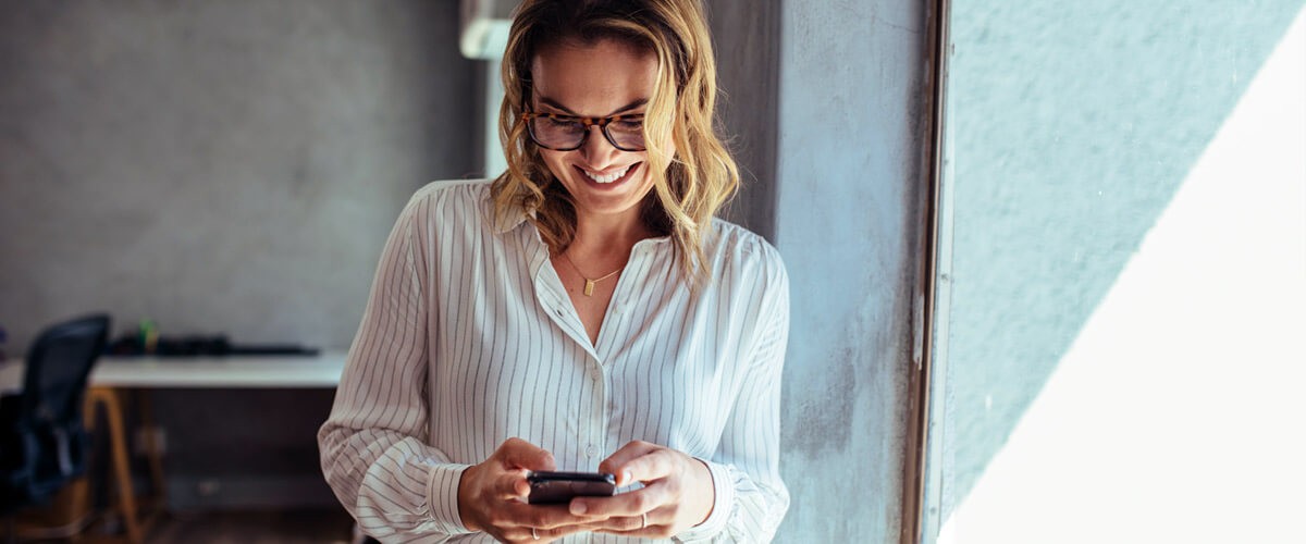  Business woman communicating with client on her smart device. 