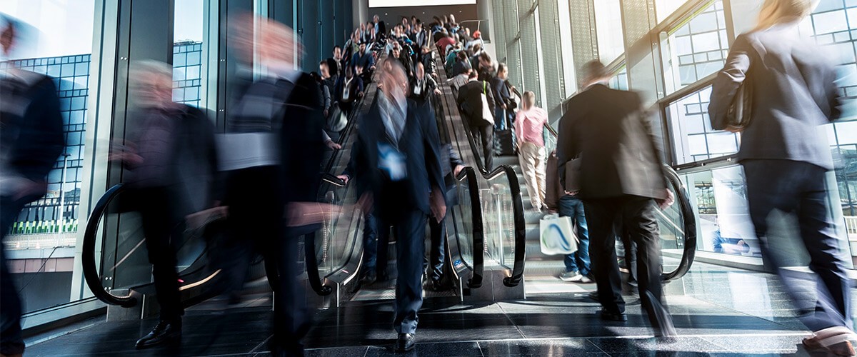 Business professionals riding escalator. Outsourced IT management.