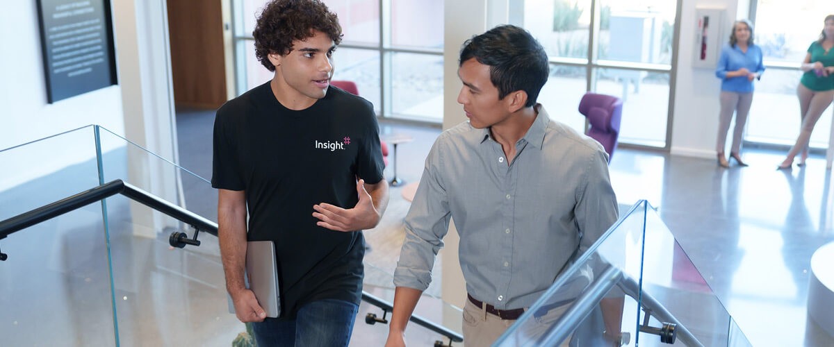 Insight teammates have discussion as they walk up the stairs. Recruitment, talent retention, hybrid work