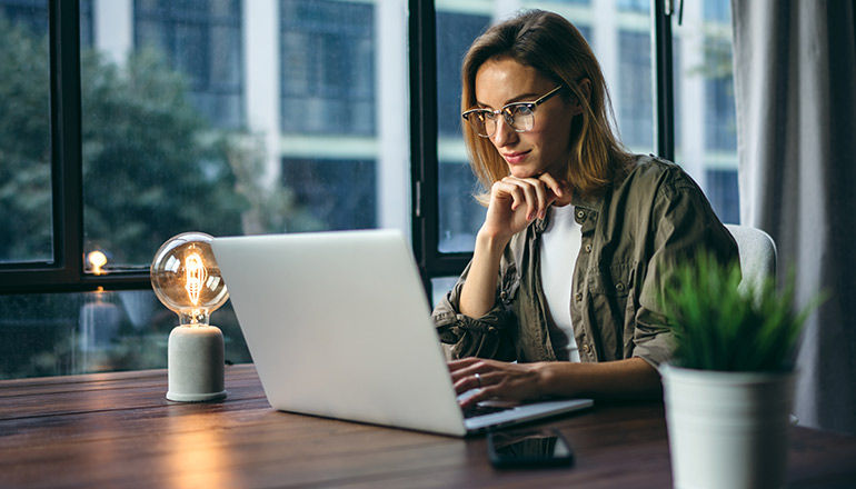 Man smiling working on laptop in office