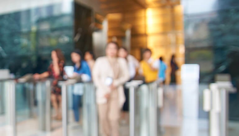 Learn how to develop a strategy to detect and prevent the spread of disease Blurred image of people coming through gates from afar. Return to work Artificial Intelligence for safety, IoT for safety, How to return to work safely