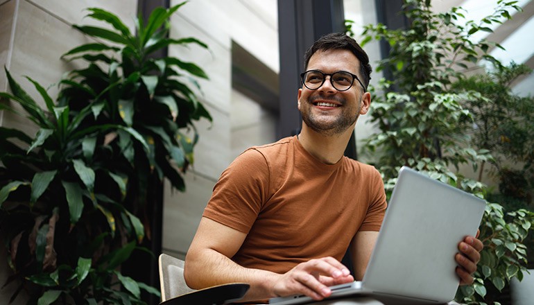 Man smiling working on laptop in office