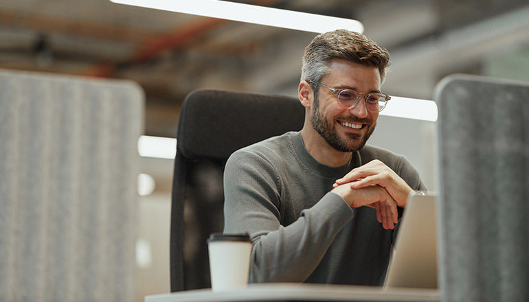Man working on laptop smiling