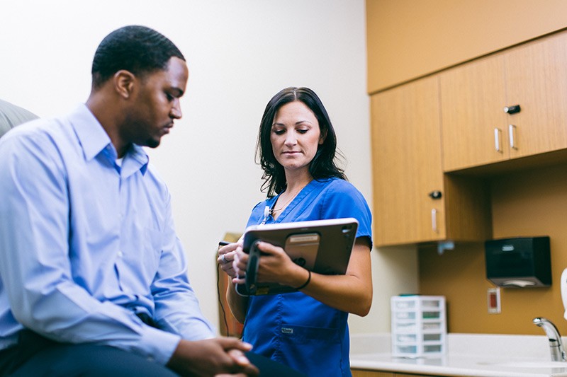 nurse-with-patient-in-examination-room-on-hp-elitepad-tablet Nurse with patient in examination room using tablet computer