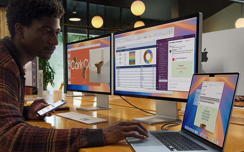 Increase Apple adoption with expert support. Two people working outside on laptops