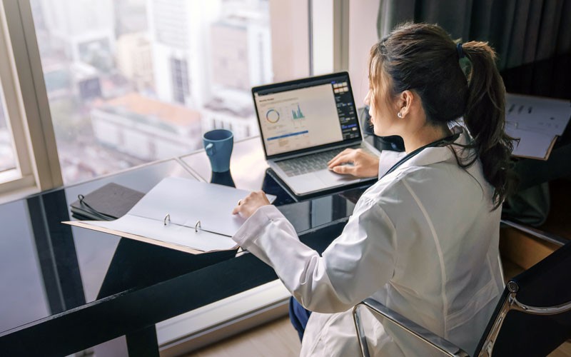 Businesswoman reviewing documents in front of cityscape window view