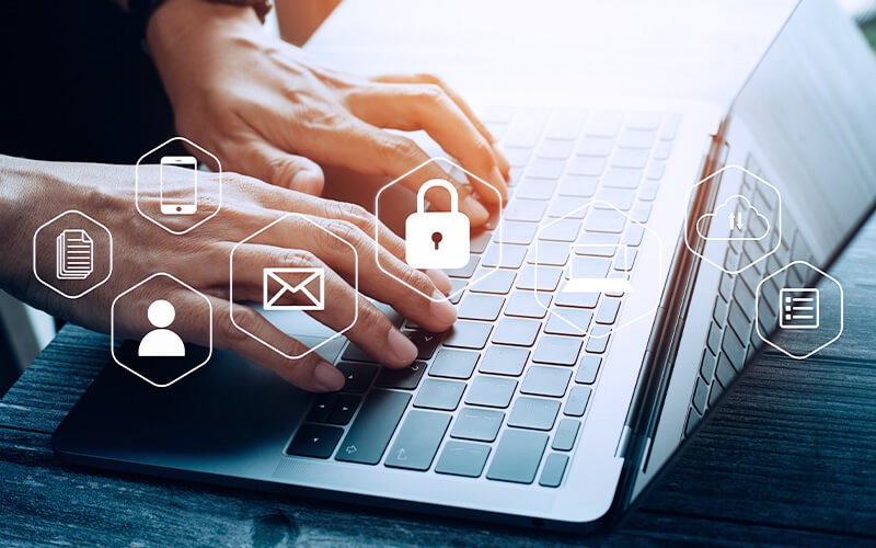 Person using a laptop with security icon and more