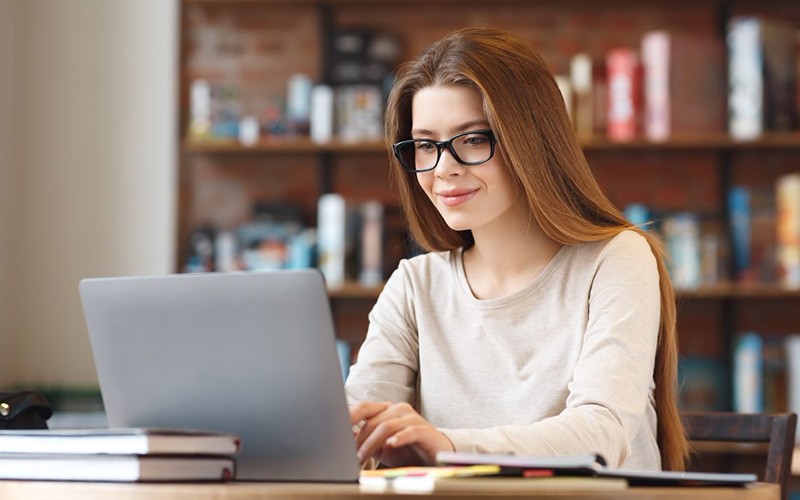 Woman with glasses working using a laptop