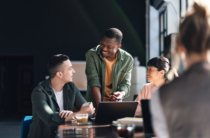 In-office team collaborating using laptops for enhanced productivity