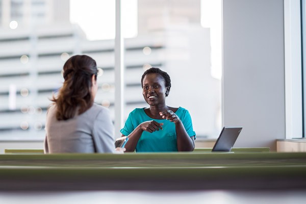 Effectively lower output costs by 30% or more with managed print services. Two government officials having a meeting
