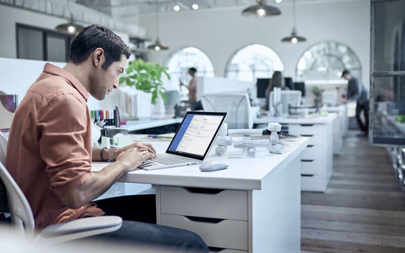 Microsoft Office 365 collaboration apps User working on Surface in open office