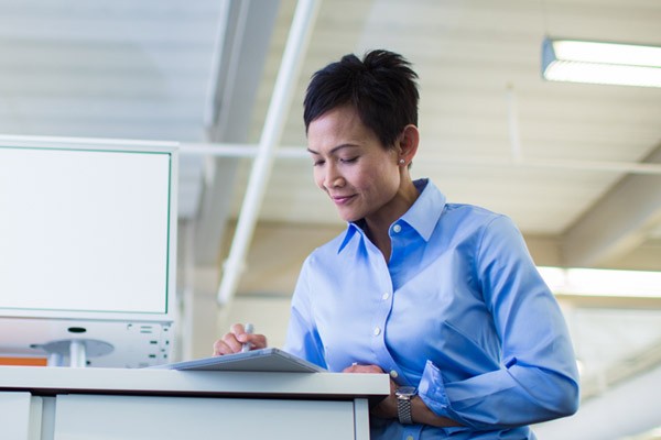 Business professional on tablet at office desk