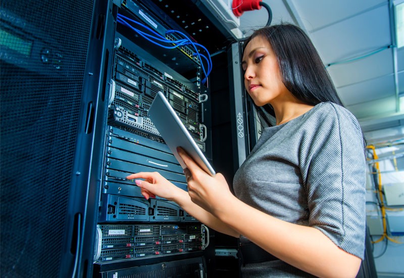Woman in database server room on tablet