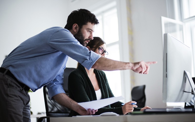 Man and woman collaborating on desktop computer